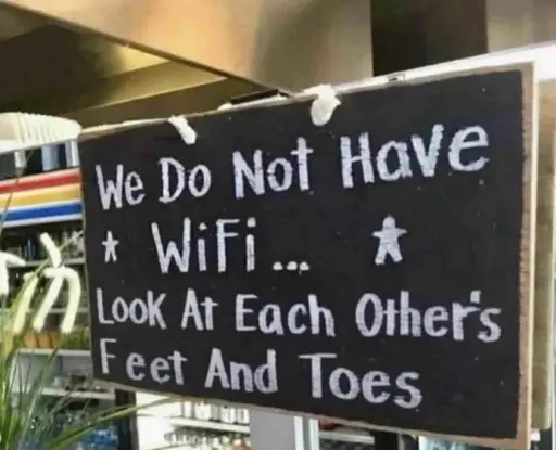 a black sign with white text that reads: "We Do Not Have WiFi... Look At Each Other's Feet And Toes."